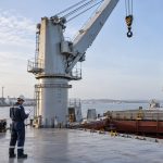 AI-generated illustration of a surveyor reviewing a cargo crane on a multipurpose vessel alongside a quay