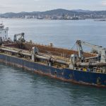 AI-generated illustration of a trailing suction hopper dredger with an open hopper and stowed suction pipe